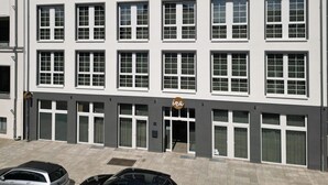 Ein modernes Hotelgebäude mit mehreren Etagen, großen Fenstern und einem Schild, das es als Hotel kennzeichnet.