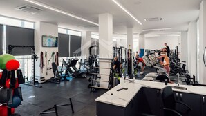 Een moderne sportschool met diverse trainingsapparaten, grote ramen en een schoon, minimalistisch design.