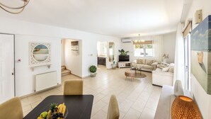 A spacious living area with a dining table, sofa, and TV. - SunnyVillas: 3BR Family Villa☆Private Pool (Protaras)