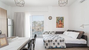 Una habitación de hotel moderna con cama, escritorio y zona de comedor.