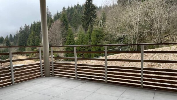A balcony with tiled flooring and metal railings, overlooking a forested area. - Appartement - Au Cœur du Lac Blanc (Orbey)