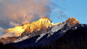 Une chaîne de montagnes aux sommets enneigés, sous un ciel dégagé.