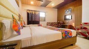 A hotel room with a large bed, a television, and a sofa. - Hotel Star Metro Inn By GRB (Amritsar)