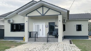 Una casa de dos pisos con porche delantero, garaje y un pequeño camino de entrada.