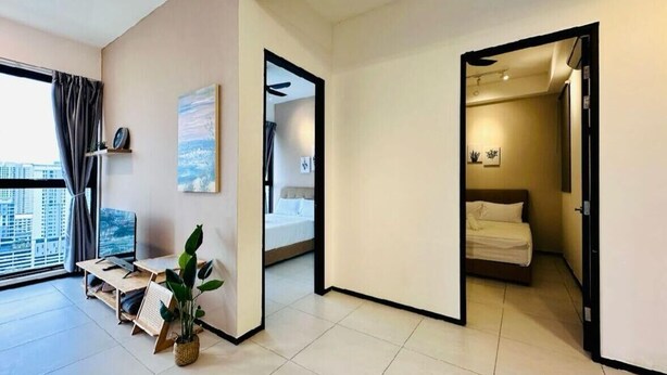 Un apartamento moderno con un ventanal grande, un escritorio con computadora, una cama y una planta.