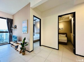 Un apartamento moderno con un ventanal grande, un escritorio con computadora, una cama y una planta.