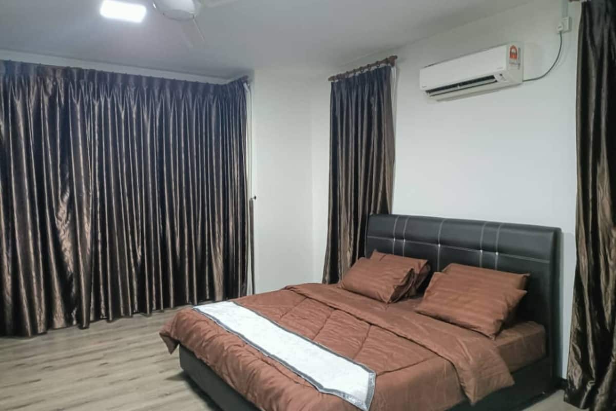 A bedroom with a bed, curtains, an air conditioning unit, and a ceiling fan.