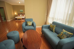 Una sala de estar moderna con un conjunto de sofá, otomanas y una mesa de centro redonda.