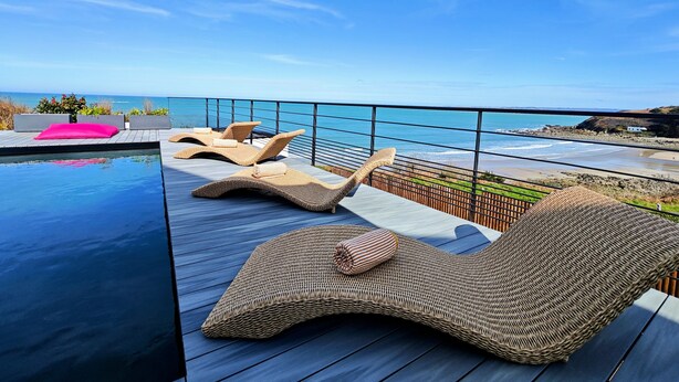 A rooftop pool area with lounge chairs and a view of the ocean. - Aux 3 Bains - Plage, Piscine, Spa (Locquirec)