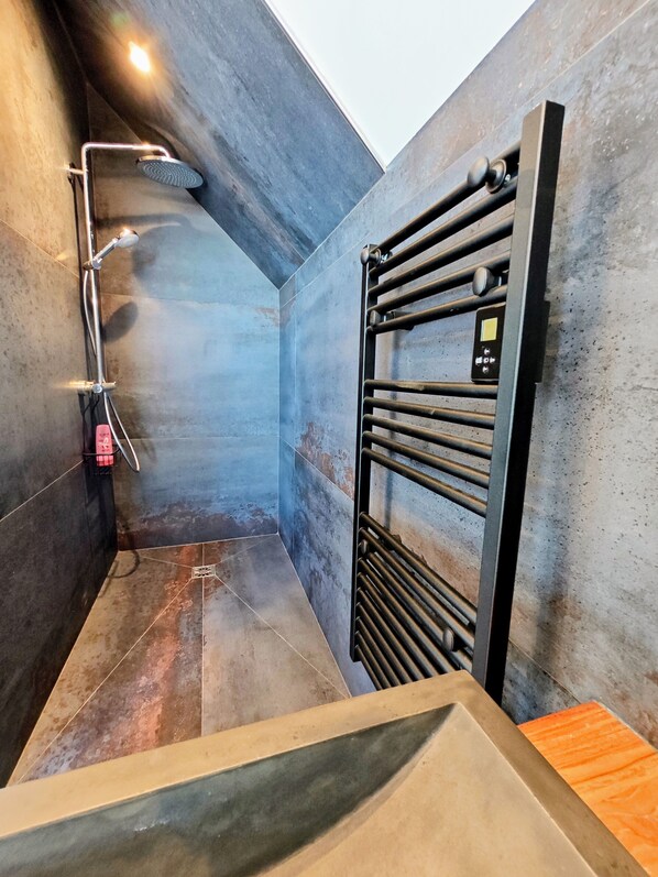A modern shower area with a built-in rain showerhead, a control panel, and a metal towel rack. - Aux 3 Bains - Plage, Piscine, Spa (Locquirec)
