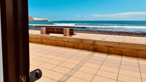 A tiled walkway leading to a beach with a bench and a view of the ocean. - Bright Sun House with Sea Views (Agüimes)