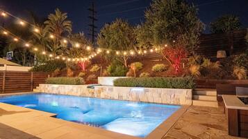 Relax by the pool surrounded by lush greenery and enjoy the tranquil atmosphere.