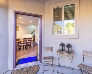 Una habitación con comedor, una escalera y una ventana con persianas.