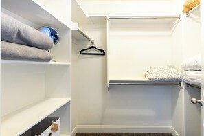Un dressing avec des étagères, une tringle et un lit escamotable.