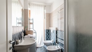 Un baño con lavamanos, bidé e inodoro.