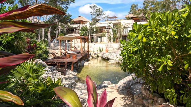 A resort with a pool, outdoor seating, and lush greenery. - Splendid Penthouse, Rooftop Plunge Pool, 2 Cenotes (Tulum)