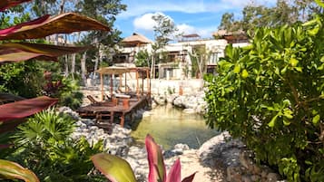 A resort with a pool, outdoor seating, and lush greenery.