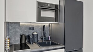 A modern kitchen with a built-in oven, a stainless steel sink, and a compact coffee maker. - Casa Di Natalia (C6QG+8CQ Rhodes, Greece)