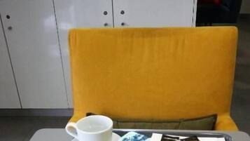 Ein Frühstückswagen mit Croissants, Orangensaft und einer Tasse auf einem Tisch in einem Hotelzimmer.