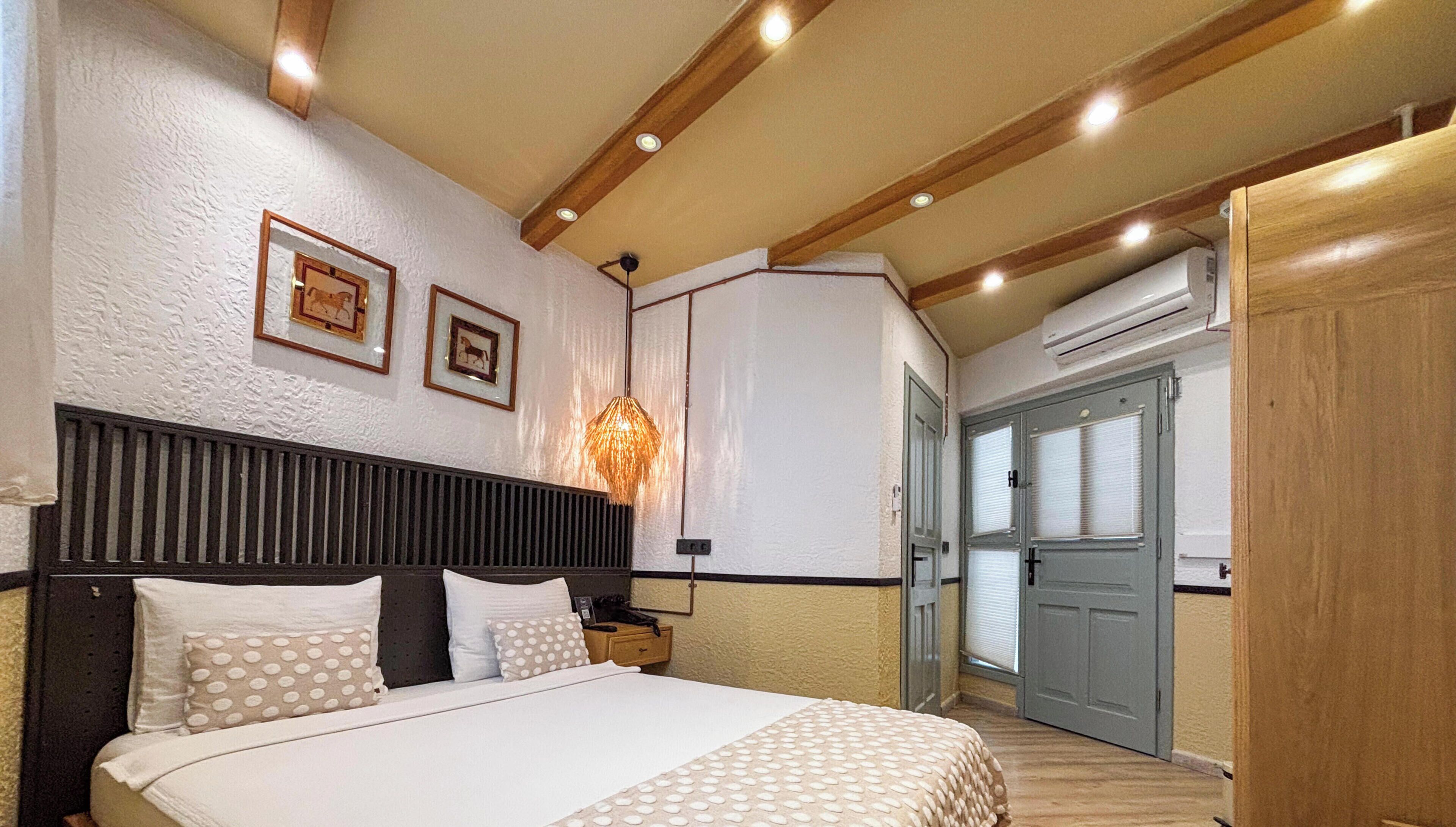 A bedroom with a bed, a bedside table, a lamp, and a wardrobe.