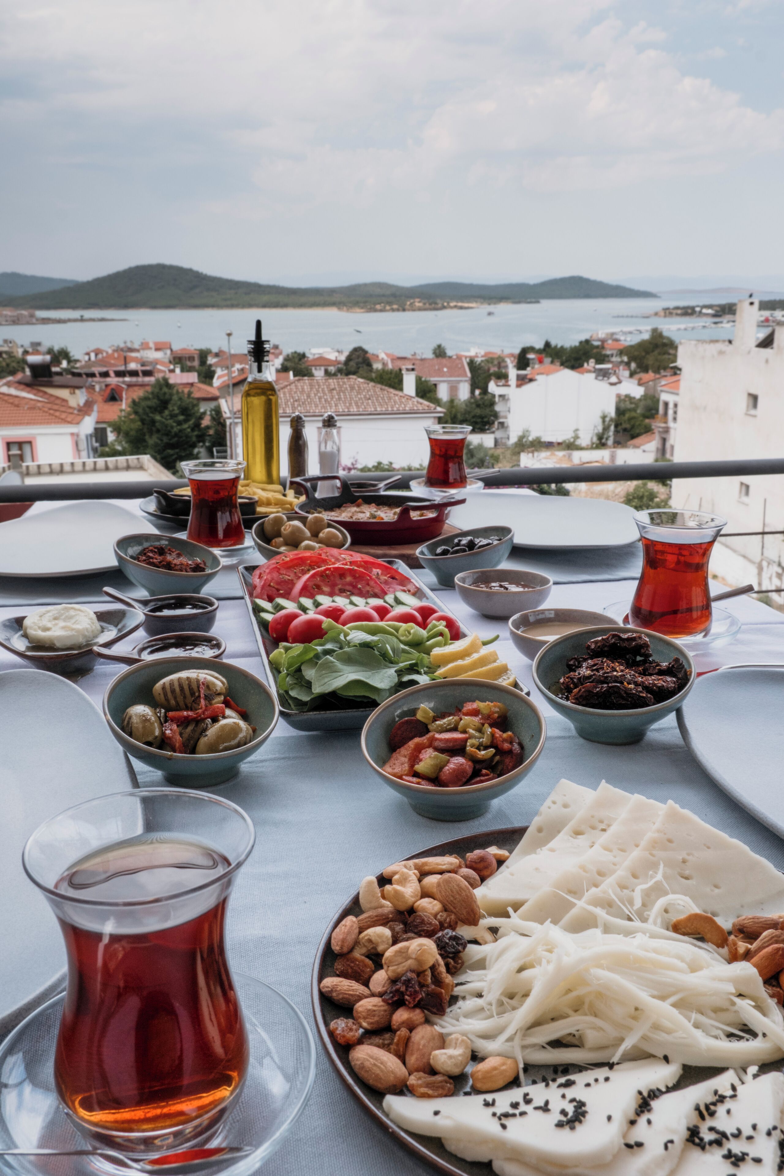 A table with various dishes and a view of a coastal town.