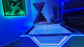 Une salle de bain moderne dotée d’un grand lavabo éclairé et d’un miroir fixé au mur.