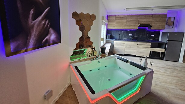 Une cuisine moderne dotée d’un jacuzzi intégré, de meubles en bois et d’une grande fenêtre.