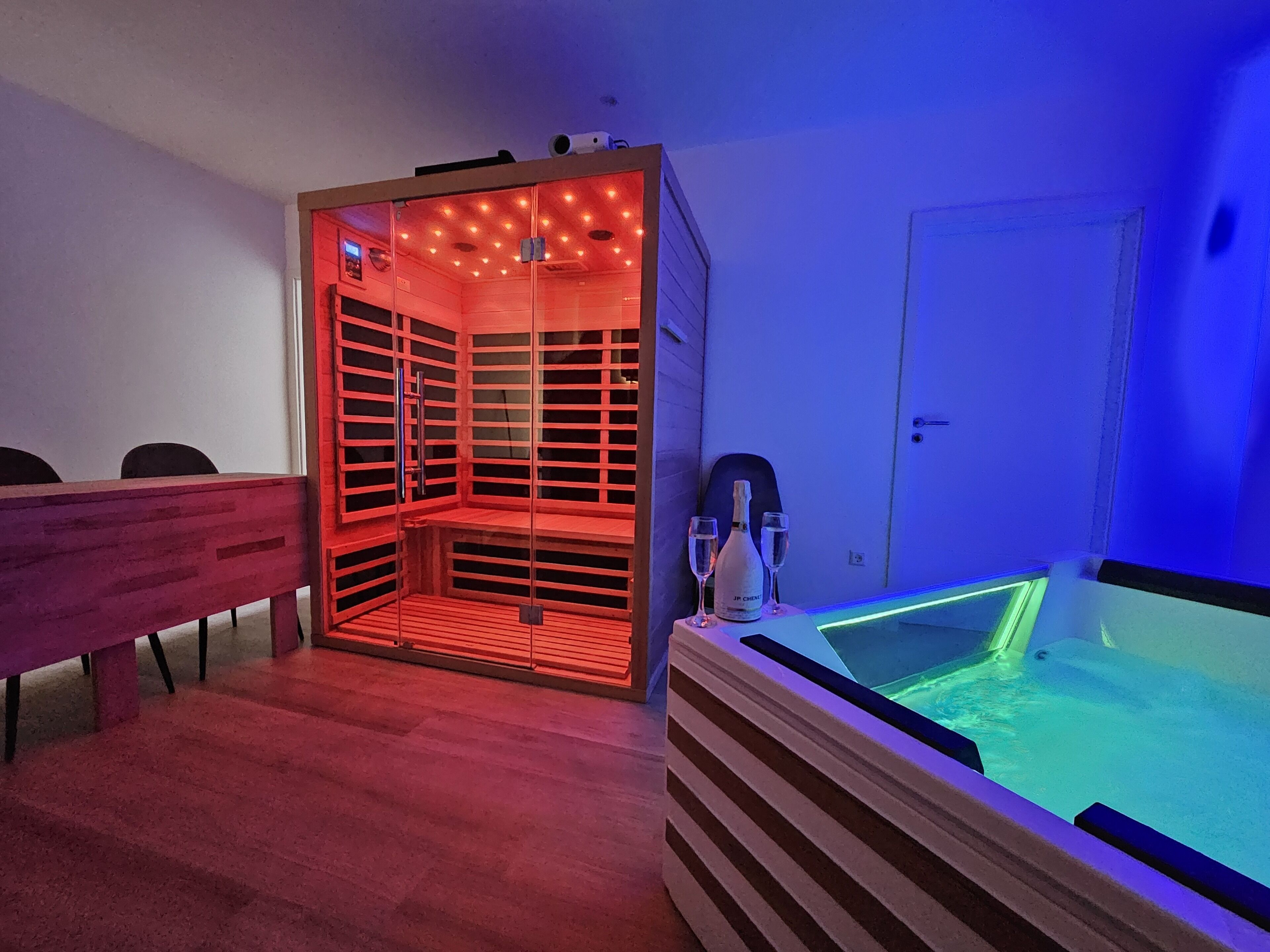 Una habitación con sauna, mesa de masajes y una pequeña zona de piscina.