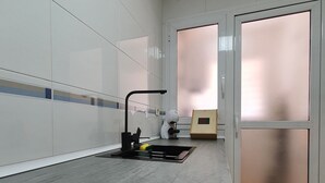 Une cuisine moderne avec des meubles blancs, un évier en acier inoxydable et un robinet noir.