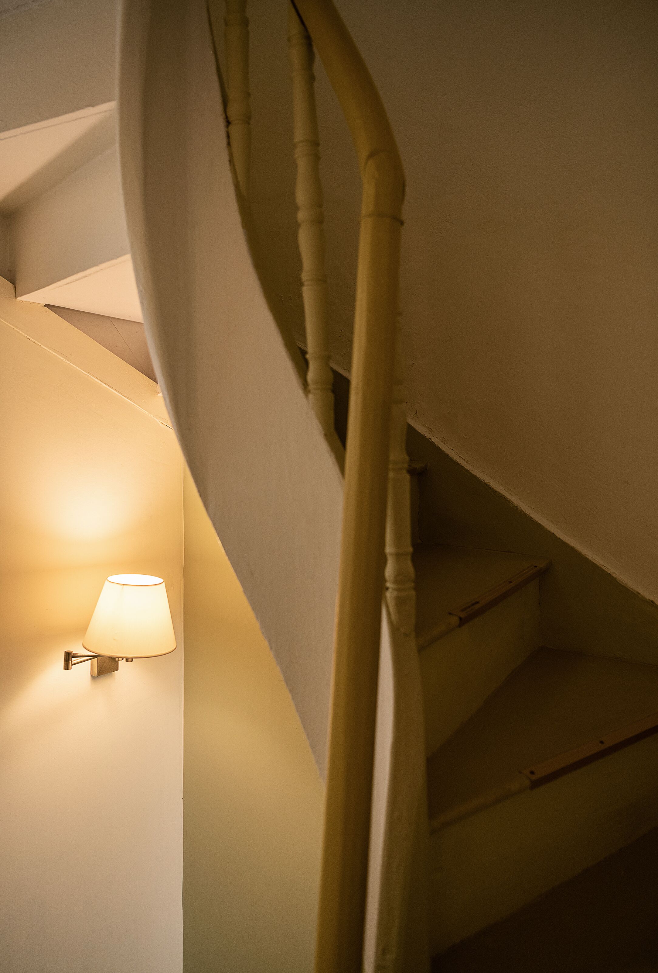 Un escalier avec une lampe fixée au mur.