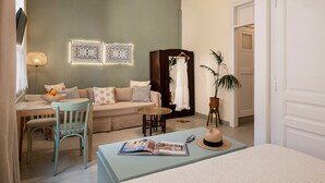 Una sala de estar acogedora con un sofá, una mesa de comedor y una mesita auxiliar.