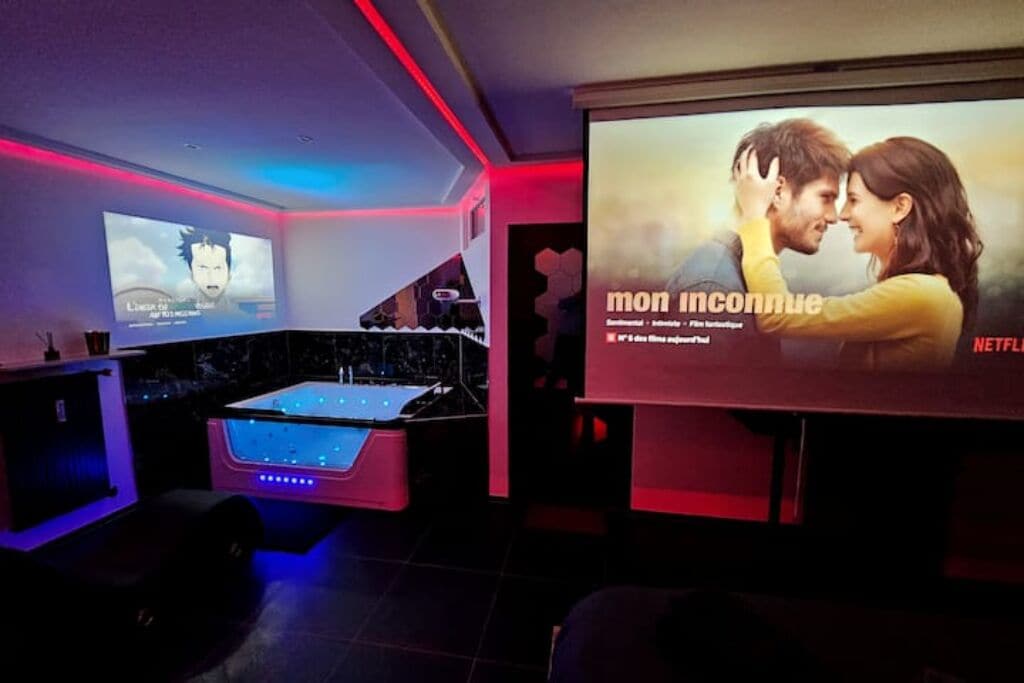 Een bioscoopzaal met een groot scherm, een pooltafel en sfeerverlichting.