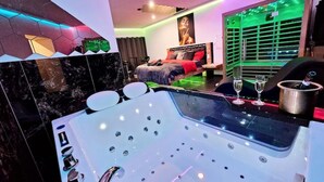 A modern bathroom with a large bathtub, a shower area, and a vanity with a mirror. - Magnifique Suite Spa Luxembourg (Differdange)