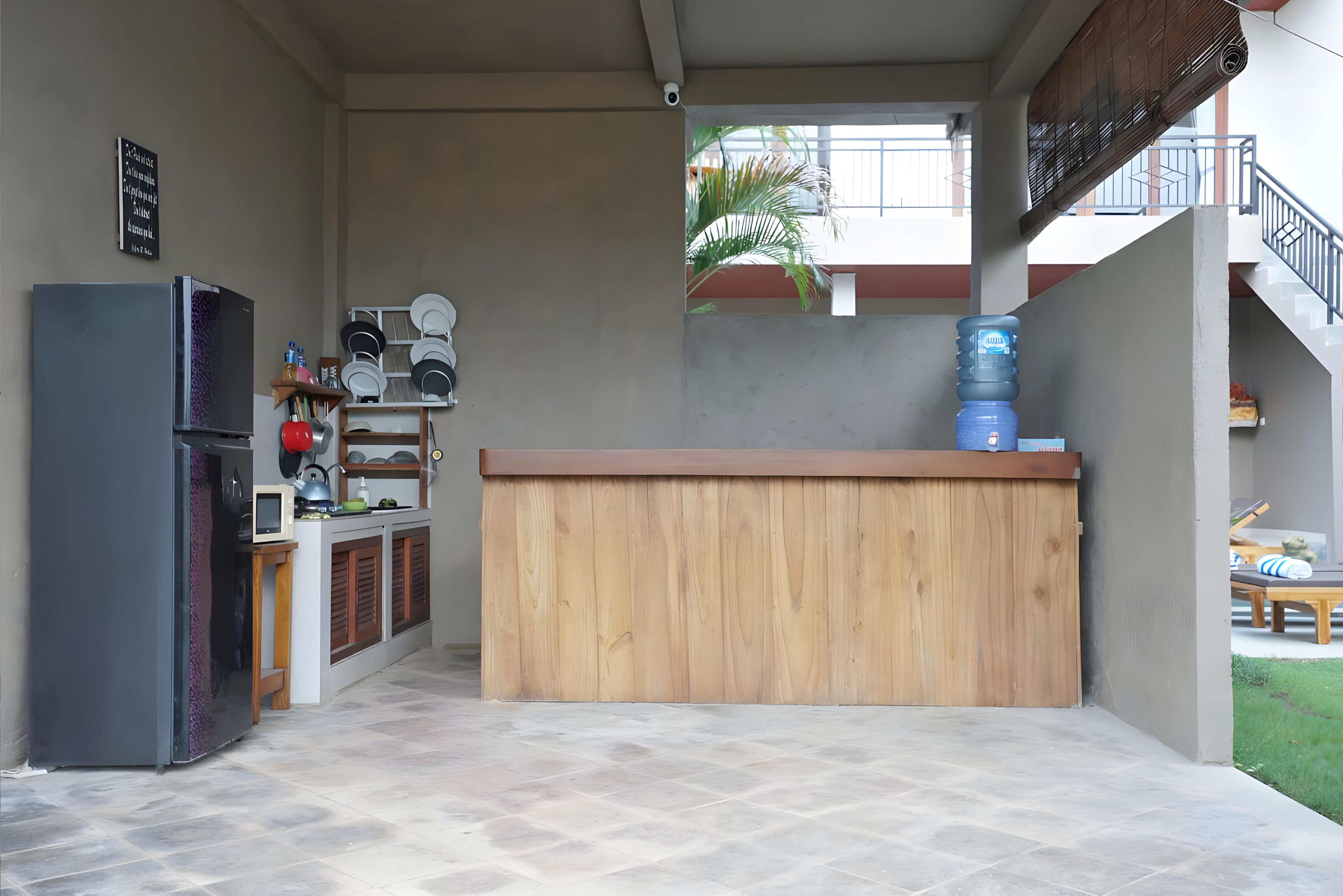 A compact kitchen with a wooden counter, a refrigerator, and a water dispenser.