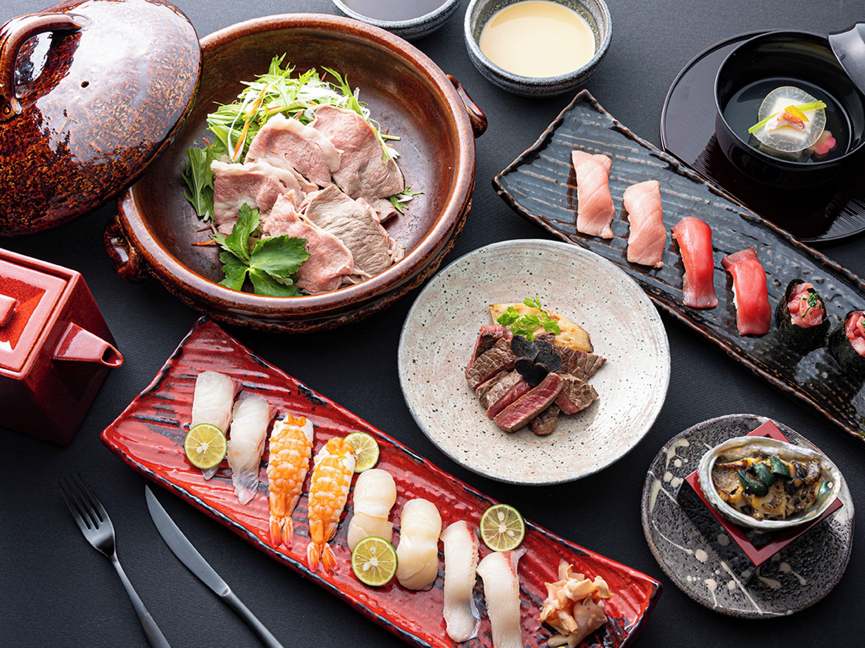 Variedad de platos que incluyen sashimi, carne a la parrilla y mariscos, dispuestos en diferentes platos y recipientes.