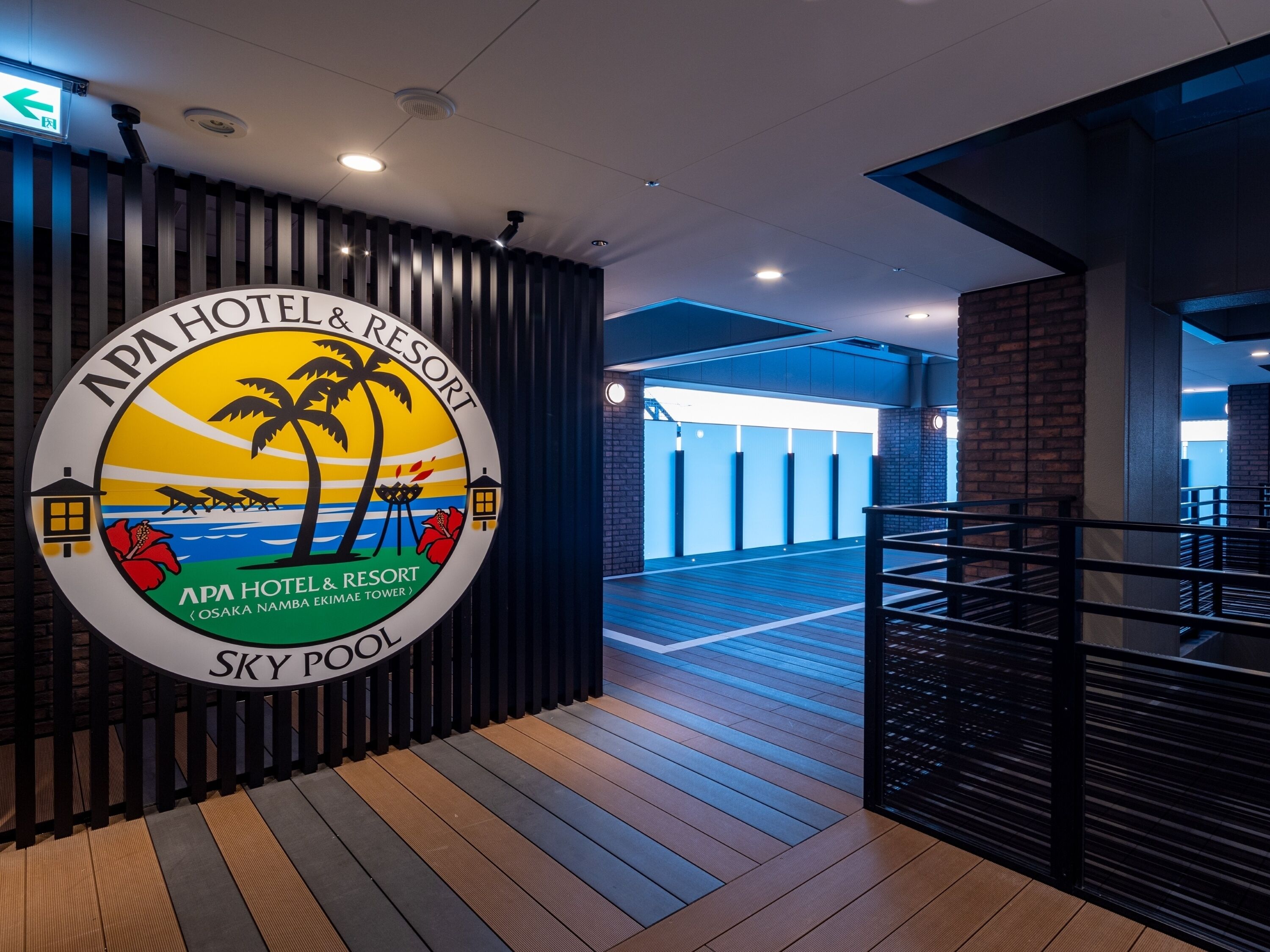 A hotel sign with a tropical theme, a wooden floor, and a modern interior design.