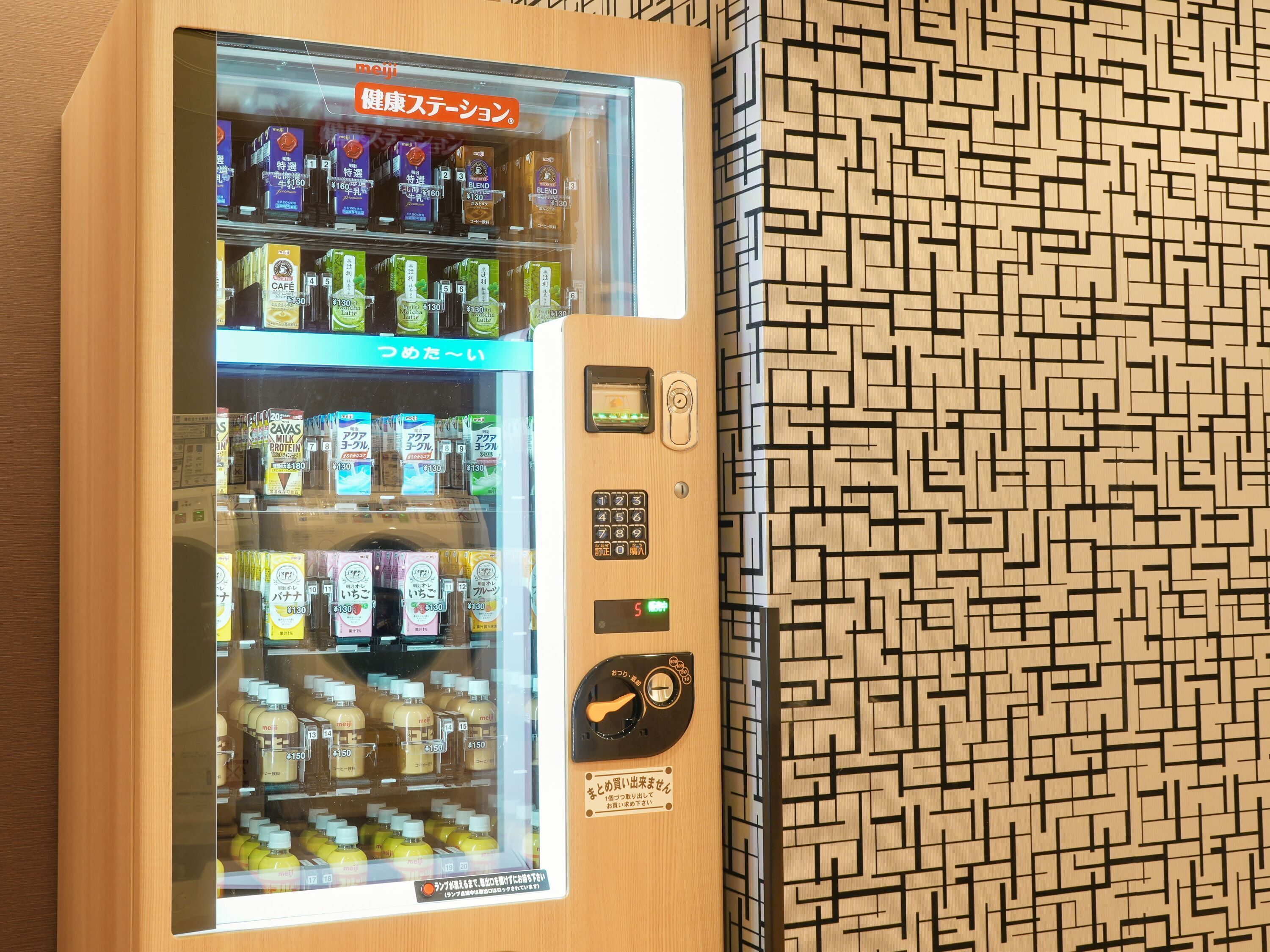 A vending machine with various beverages and snacks, including a section labeled 'Café' and another with 'Milk Protein'.