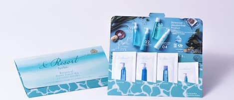 A botanical hotel travel kit with a blue and white design, including a booklet and four skincare products.