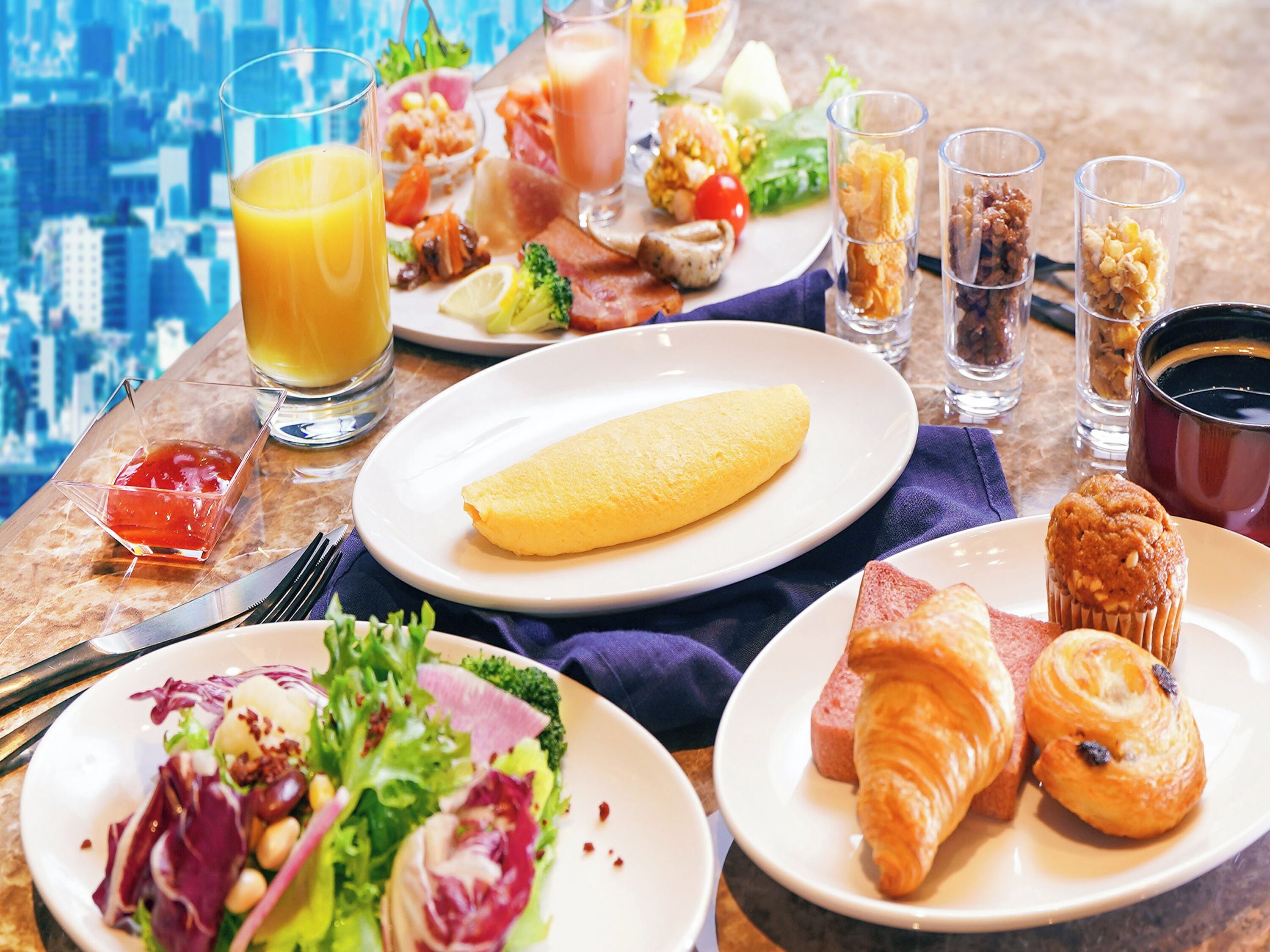 A breakfast buffet with various dishes, including eggs, pastries, and a salad.
