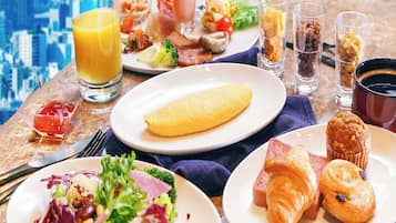 Un buffet de petit-déjeuner proposant divers plats, notamment des œufs, des viennoiseries et une salade.