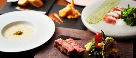 Variedad de platos sobre una mesa de madera, incluyendo un plato con salsa verde, un plato con salsa blanca y un plato con salsa roja.