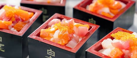 A series of square containers with a red rim, each containing a mix of diced fruit and a white substance, possibly a dessert or condiment.