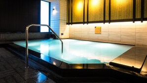 Una piscina interior moderna con techo de madera y paredes de azulejos.
