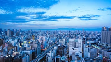 A cityscape with a dense urban environment, featuring a variety of building types and a prominent bridge structure.