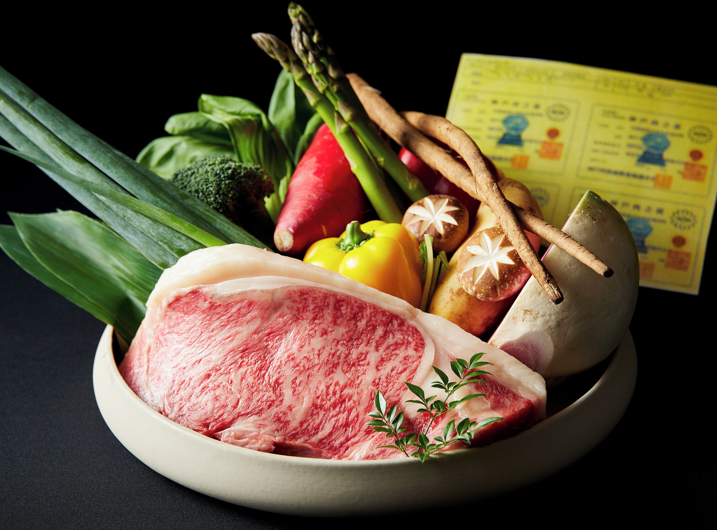 A bowl of raw meat with vegetables and herbs.