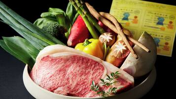 A bowl of raw meat with vegetables and herbs.