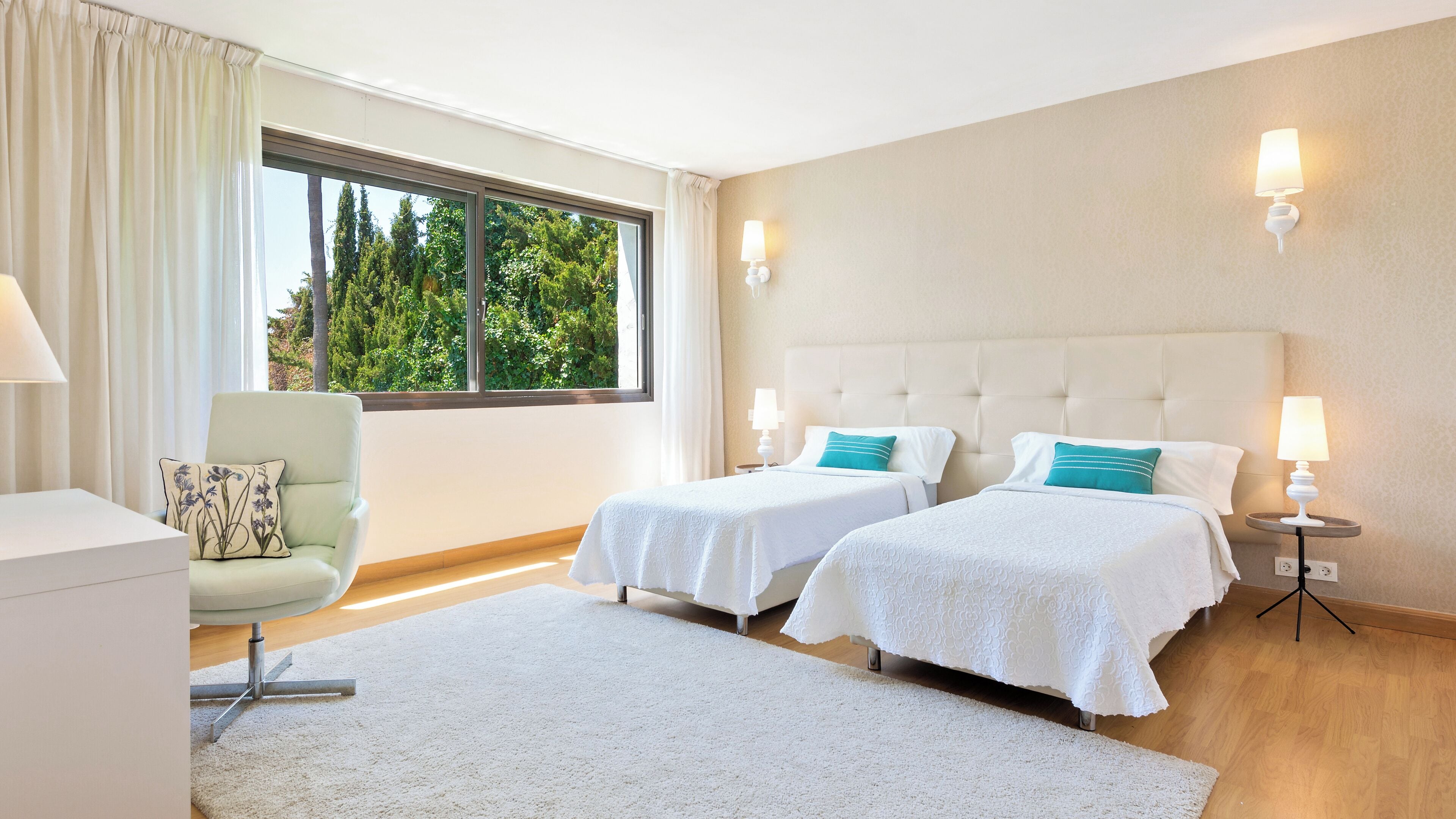 Ein Hotelzimmer mit zwei Betten, einem Schreibtisch und einem Sessel.
