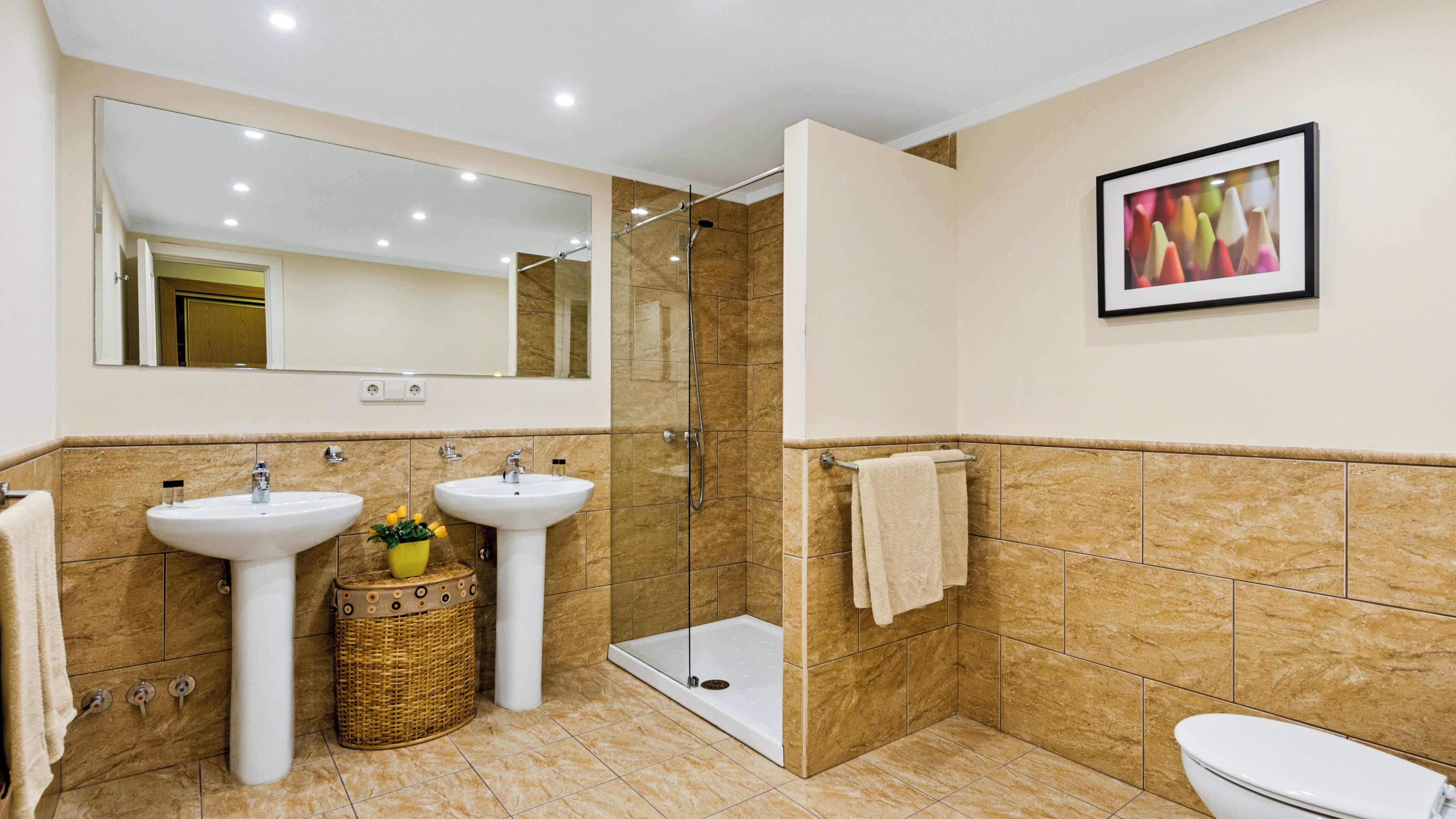 Ein modernes Badezimmer mit zwei Waschbecken, einer Dusche und einer Toilette.