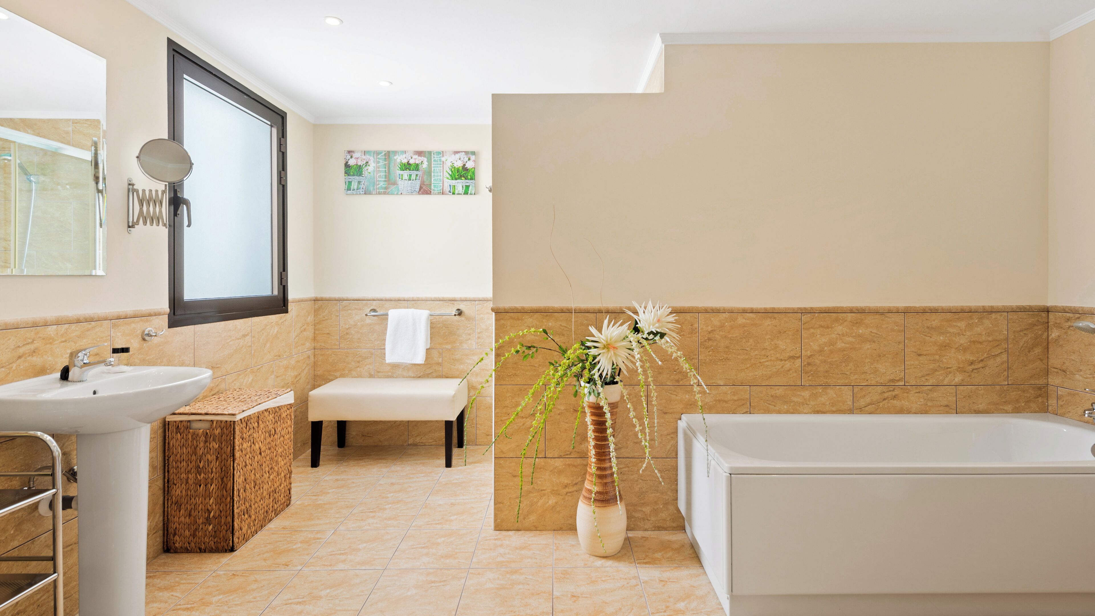 A modern bathroom with a bathtub, a sink, a bench, and a mirror.