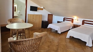 A small, cozy room with two beds, a desk, a chair, and a television. - Hotel Blue Spot (Malgrat de Mar)